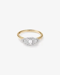 Bague de fiançailles halo en or jaune et blanc 14 carats avec trois diamants émeraude et en forme de poire totalisant 0,69 carat.
