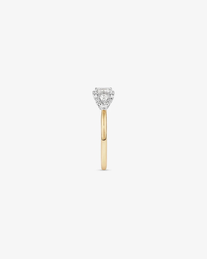 Bague de fiançailles halo en or jaune et blanc 14 carats avec trois diamants émeraude et en forme de poire totalisant 0,69 carat.
