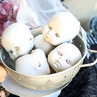 3 1/2" Halloween Plastic Doll Heads in Mesh Bag - 12 Pc.