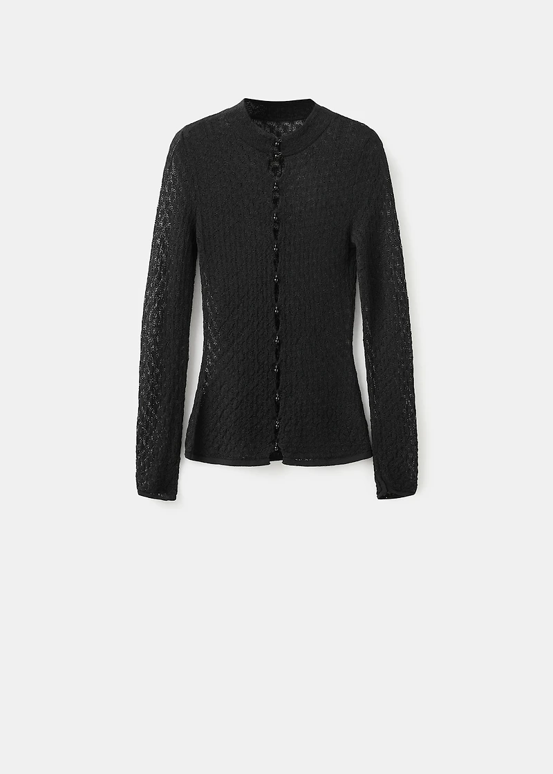 Openwork knitted sweater with bead fastening