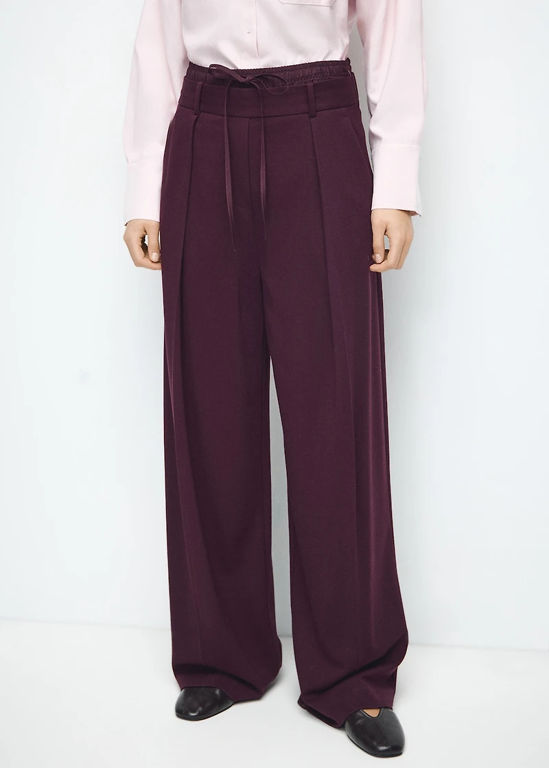 Pleated trousers with combined waistband