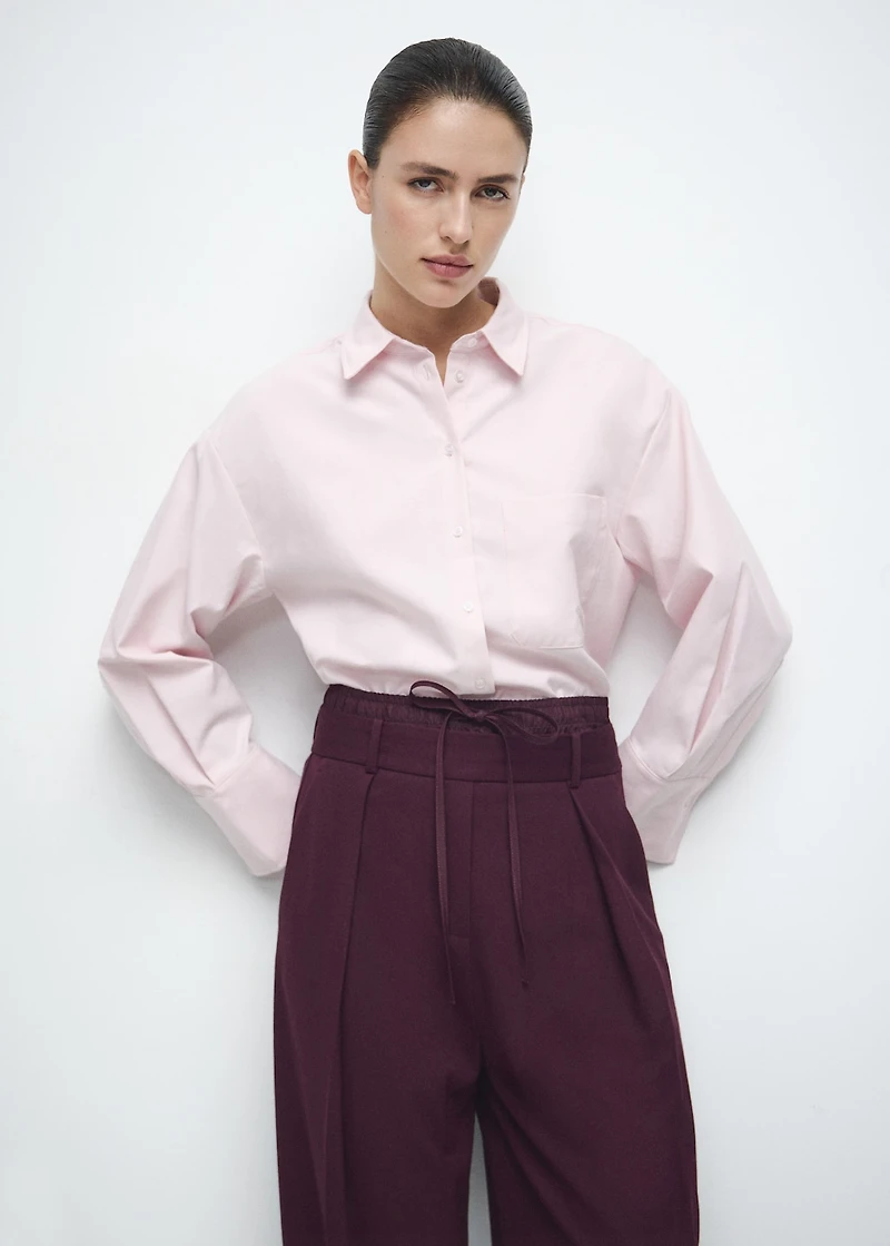 Pleated trousers with combined waistband
