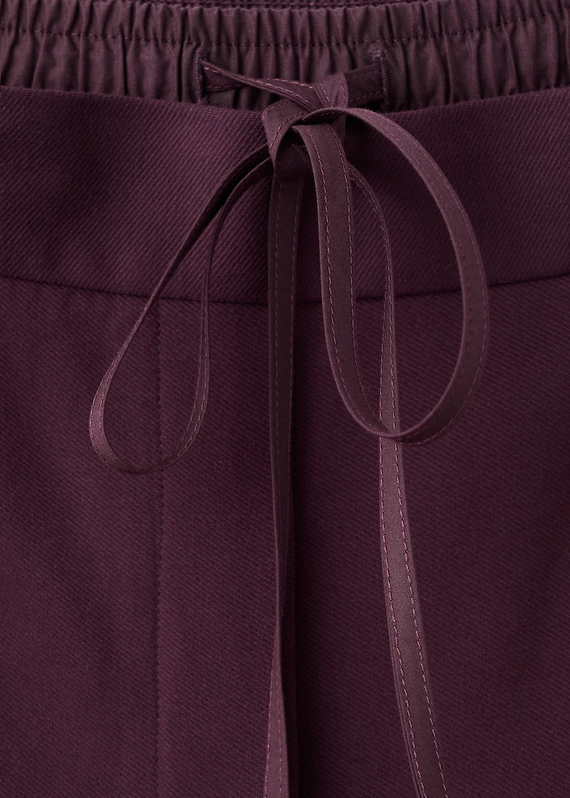 Pleated trousers with combined waistband