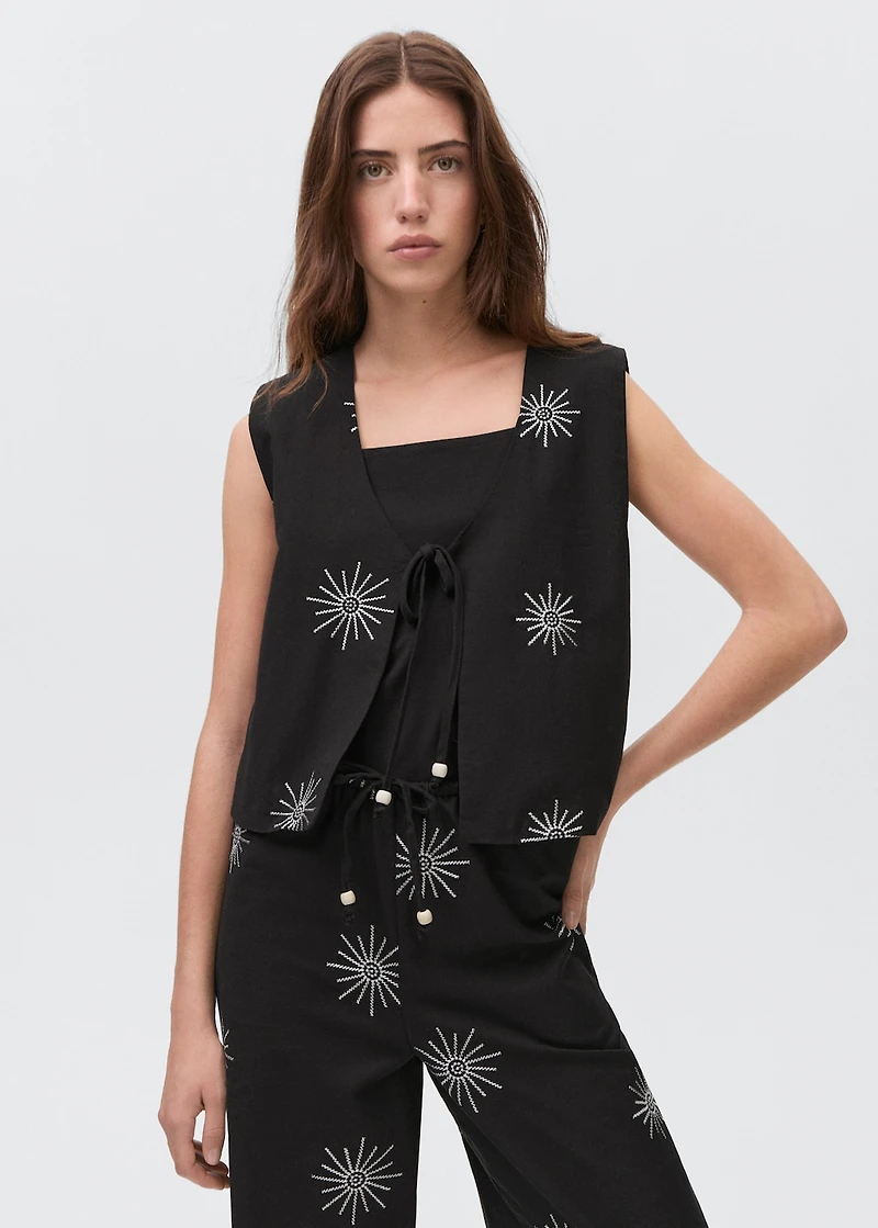 Embroidered top with bow closure