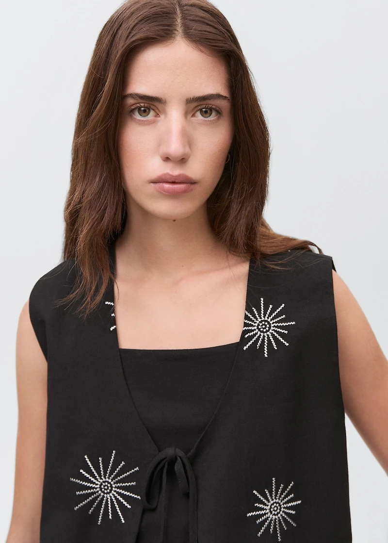 Embroidered top with bow closure