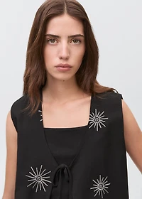 Embroidered top with bow closure