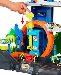 Hot Wheels 1:64 scale City Ultimate T-Rex Garage with 2 Toy Cars & Storage for 50+, Race & Stunt, Dino Nemesis