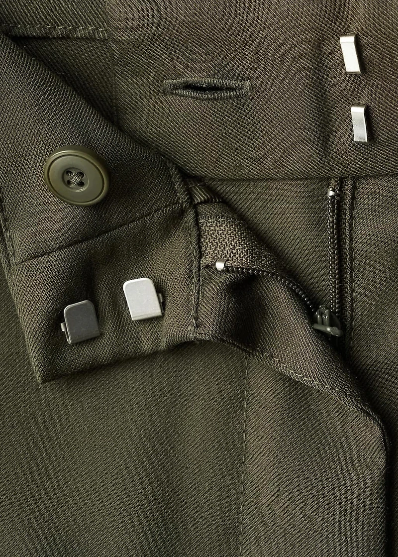 Trousers with pleats and button detail