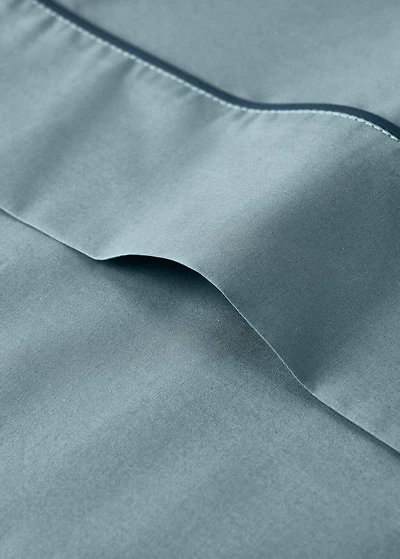 Reversible percale cotton top sheet with contrasting piping for cot