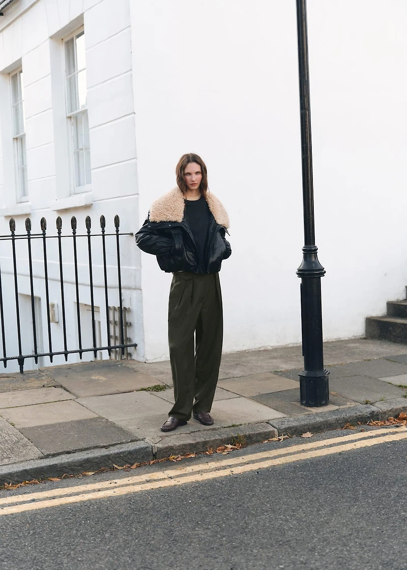 Trousers with pleats and button detail