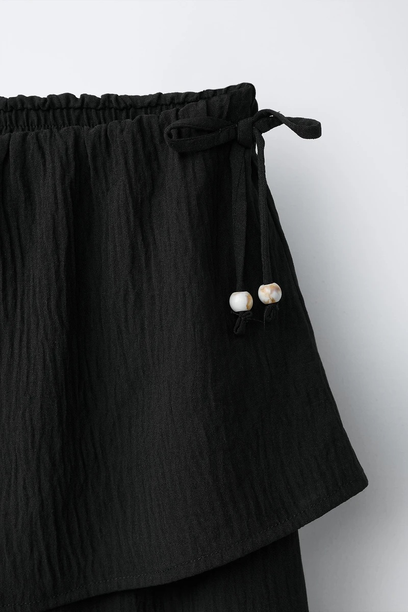 PANTALON TEXTURÉ JAMBES LARGES JUPE