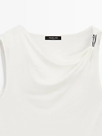 Top à col drapé et détail bijou