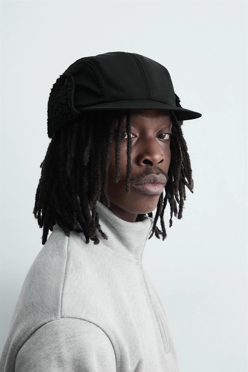 CASQUETTE TECHNIQUE AVEC CACHE-OREILLES EN IMITATION PEAU DE MOUTON