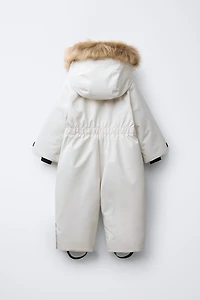 WATER RESISTANT AND WINDPROOF RECCO® SYSTEM SKI COLLECTION LONG JUMPSUIT WITH FAUX FUR HOODIE