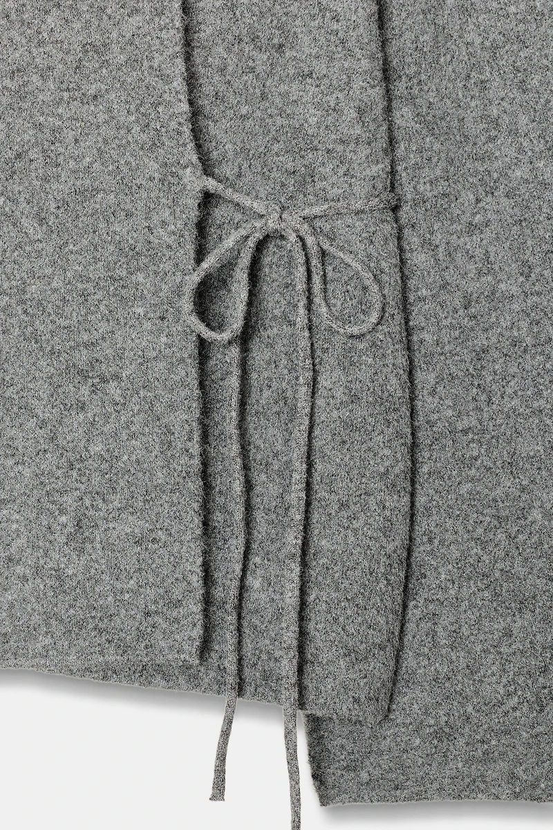 GILET EN MAILLE À OUVERTURE SUR LES MANCHES