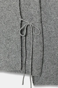 GILET EN MAILLE À OUVERTURE SUR LES MANCHES