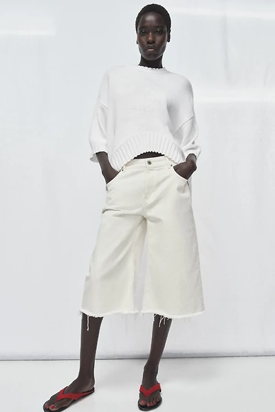 PULL EN MAILLE À MANCHES COURTES ET BAS ASYMÉTRIQUE