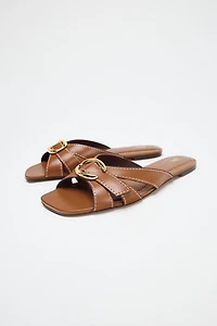 CROSSED SANDALS WITH METALLIC DETAIL