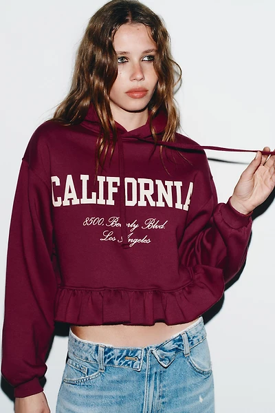 RUFFLED VARSITY SWEATSHIRT