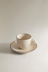 STONEWARE COFFEE CUP AND SAUCER WITH DISTRESSED RIM