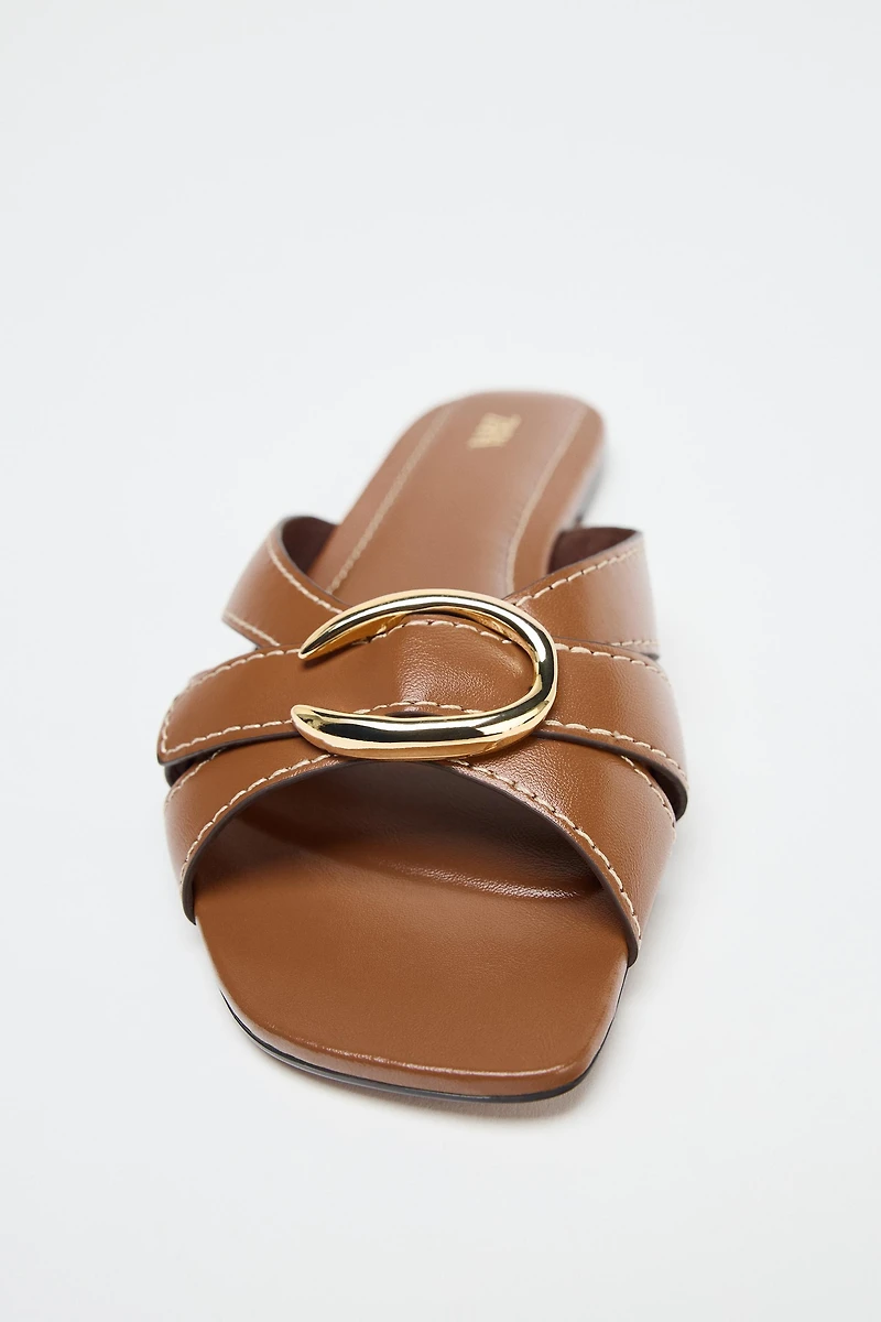 CROSSED SANDALS WITH METALLIC DETAIL