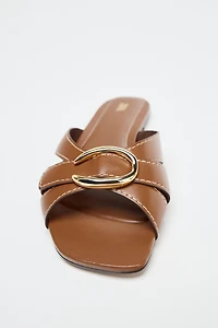 CROSSED SANDALS WITH METALLIC DETAIL