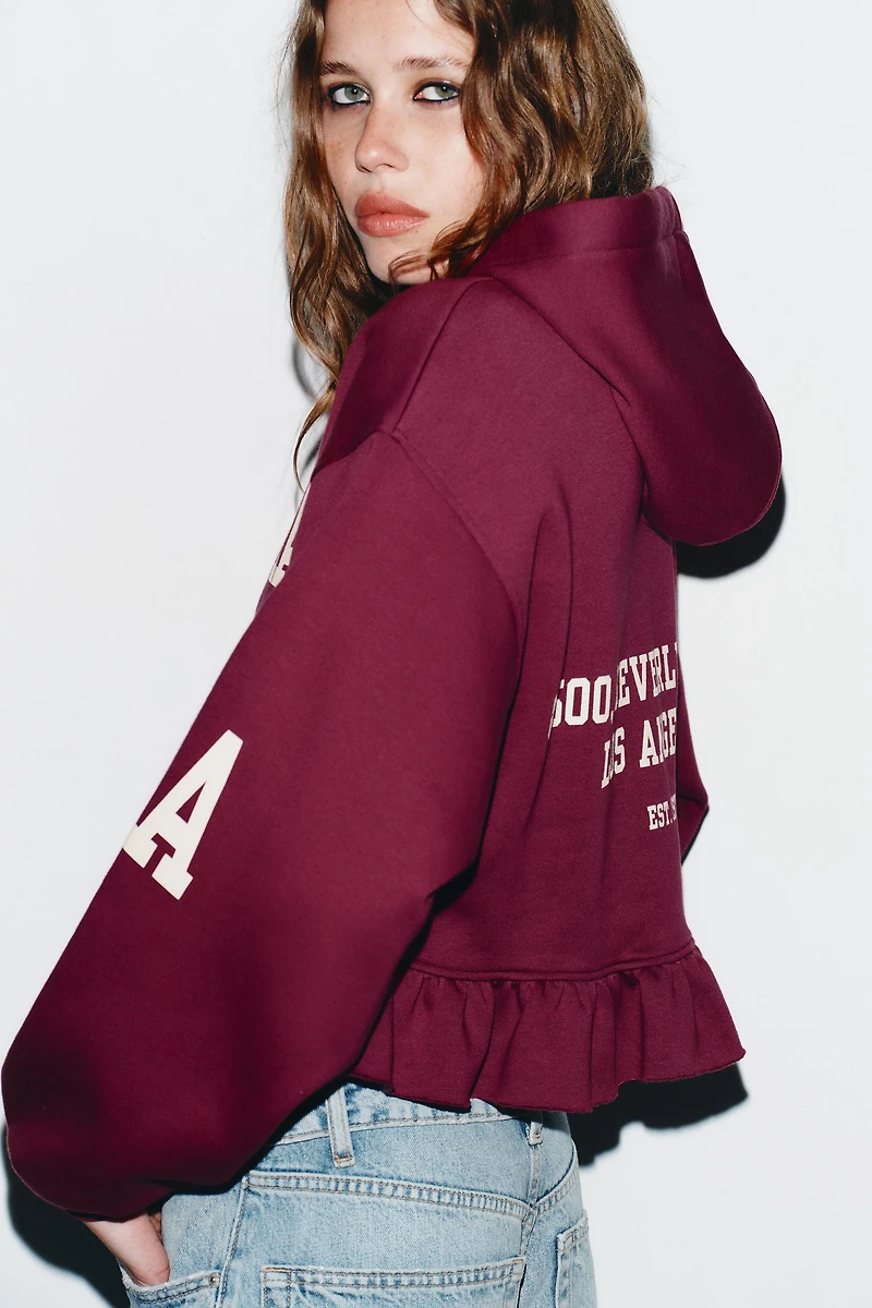 RUFFLED VARSITY SWEATSHIRT