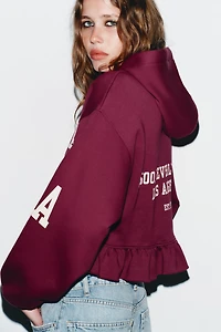 RUFFLED VARSITY SWEATSHIRT