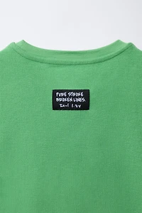 T-SHIRT SANS MANCHES AVEC INSCRIPTION EN RELIEF