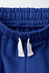 PANTALON À JAMBES LARGES ET BANDES SUR LES CÔTÉS