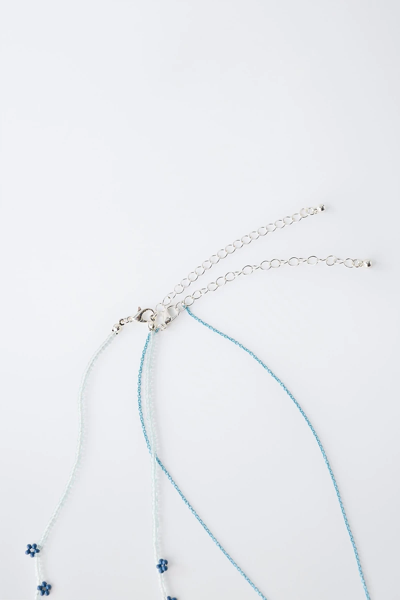 LOT DE DEUX COLLIERS FANTAISIE PAPILLON ET FLEURS