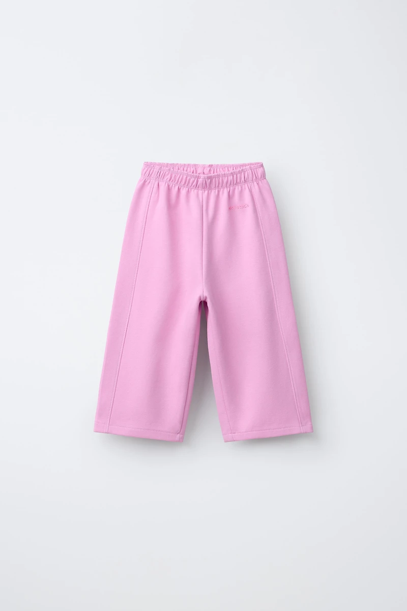 WIDE LEG INTERLOCK RAISED TEXT PANTS