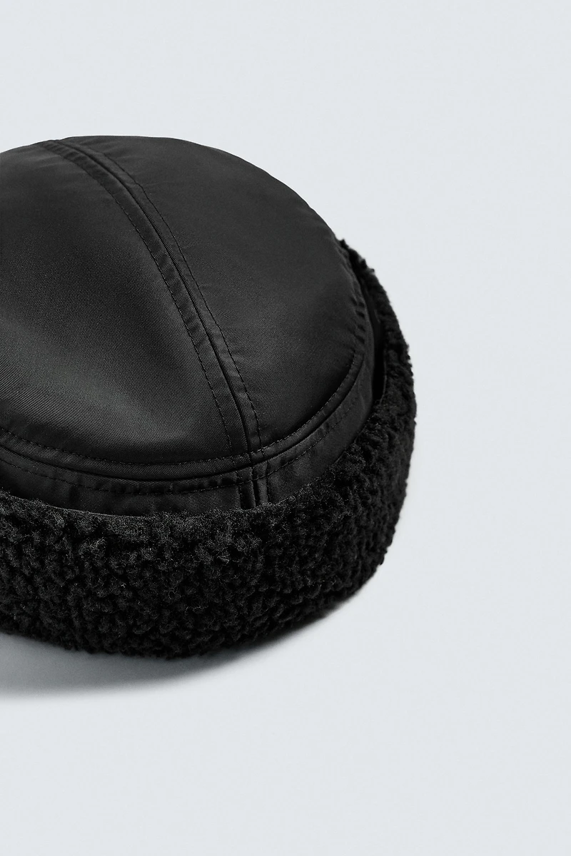 TECHNICAL CAP WITH SHEARLING EAR FLAPS