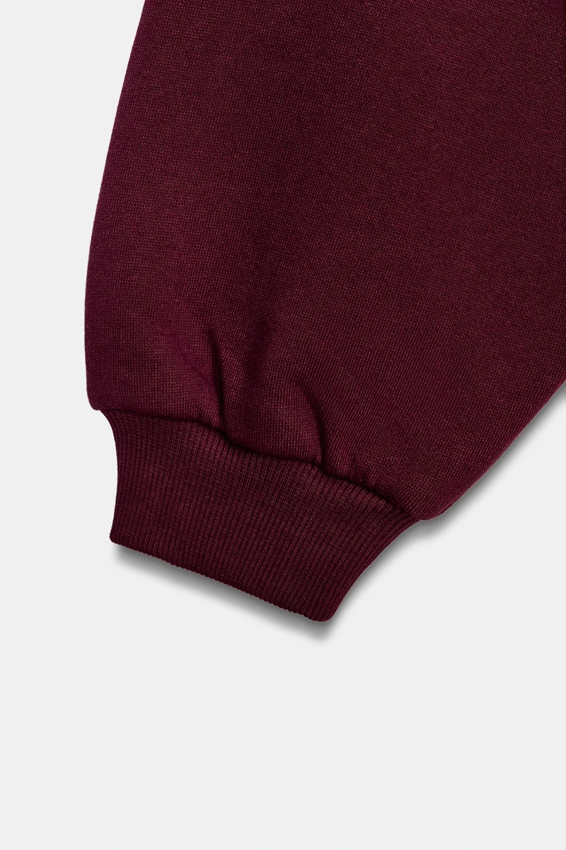 RUFFLED VARSITY SWEATSHIRT