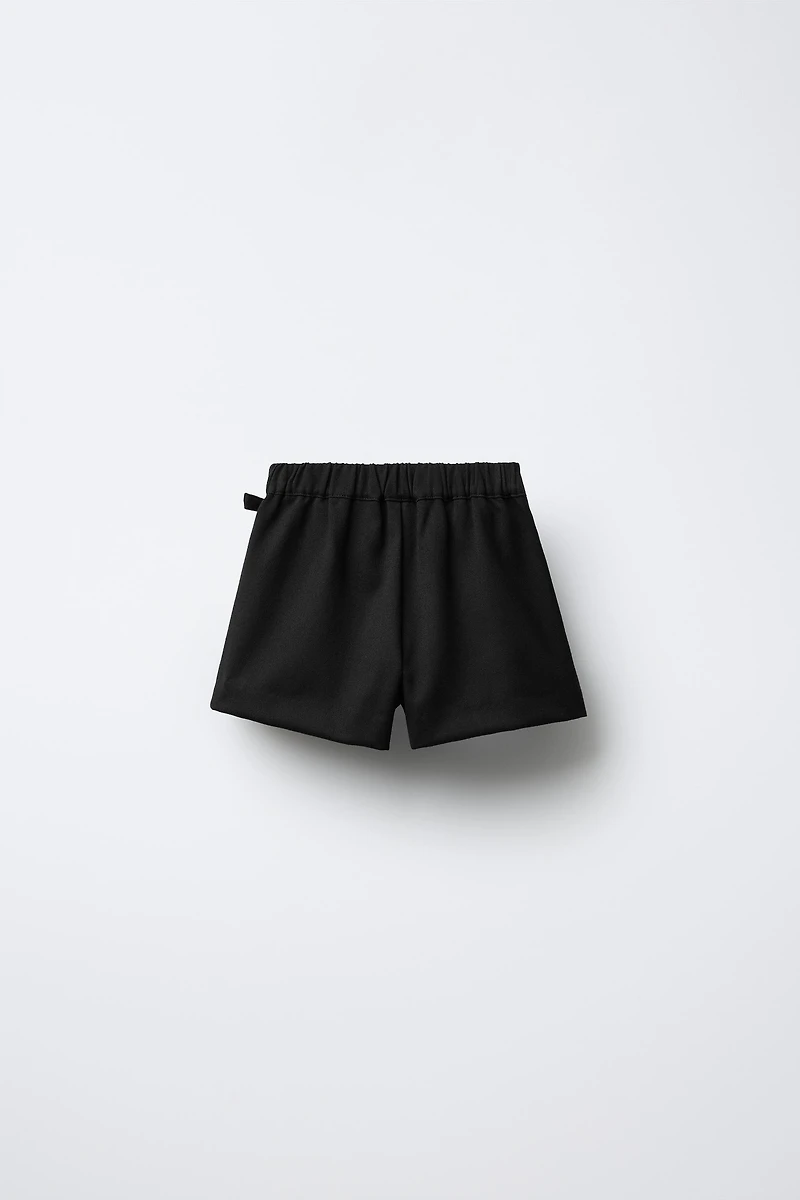JUPE-SHORT À PLIS PLATS AVEC BOUCLE