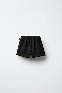 JUPE-SHORT À PLIS PLATS AVEC BOUCLE