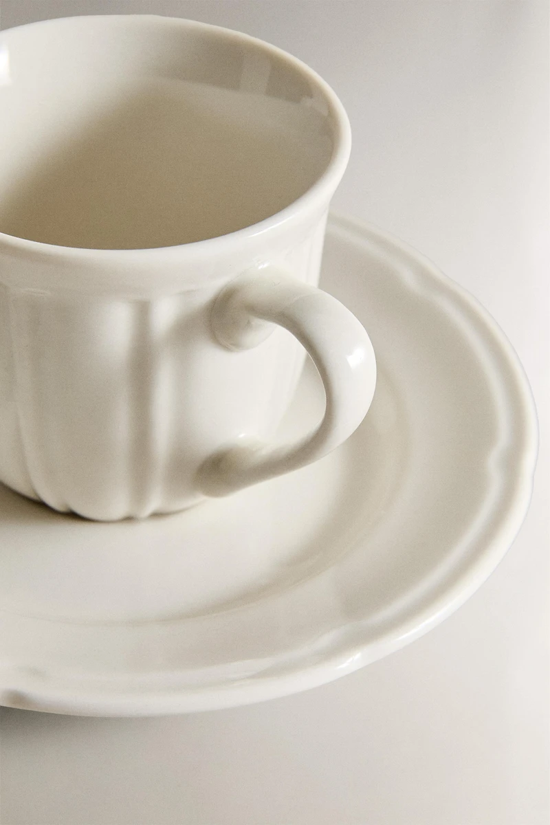 COFFEE CUP AND PORCELAIN SAUCER WITH RAISED DESIGN