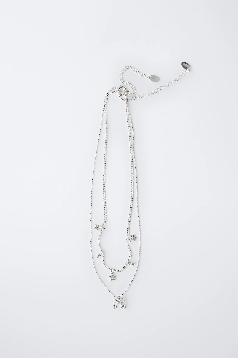 LOT DE DEUX COLLIERS AVEC PENDENTIF ÉTOILES ET CERISE