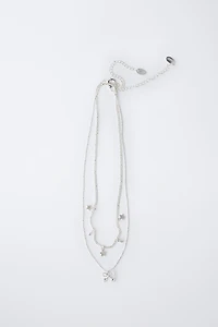 LOT DE DEUX COLLIERS AVEC PENDENTIF ÉTOILES ET CERISE