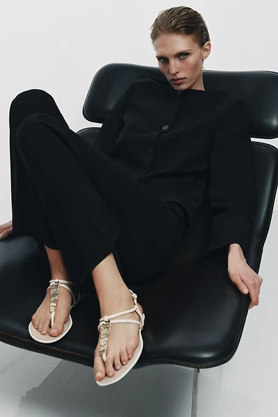 FLAT SANDALS WITH METALLIC APPLIQUES
