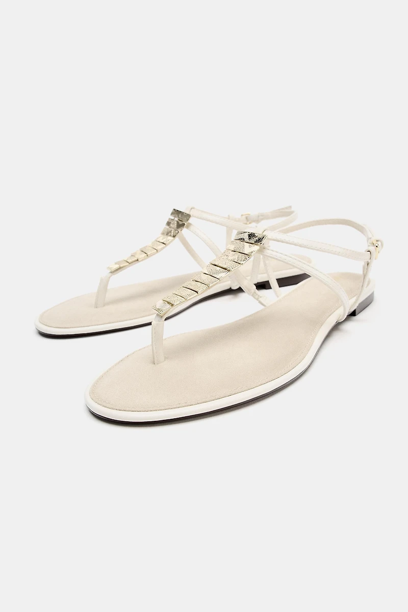FLAT SANDALS WITH METALLIC APPLIQUES