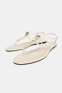 FLAT SANDALS WITH METALLIC APPLIQUES