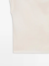 Asymmetric top with shoulder appliqué