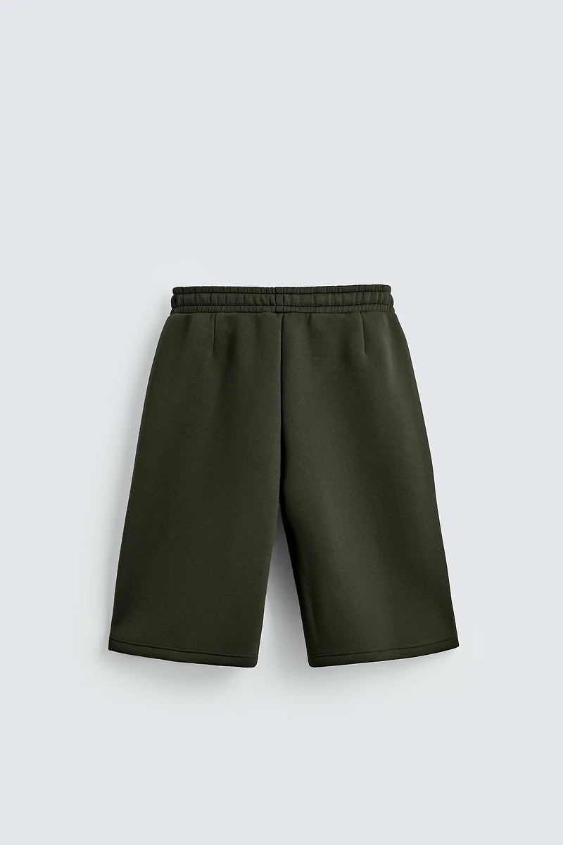 NEOPRENE EFFECT PLEATED LONG BERMUDA SHORTS