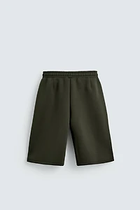 NEOPRENE EFFECT PLEATED LONG BERMUDA SHORTS