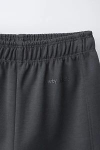 WIDE LEG INTERLOCK RAISED TEXT PANTS