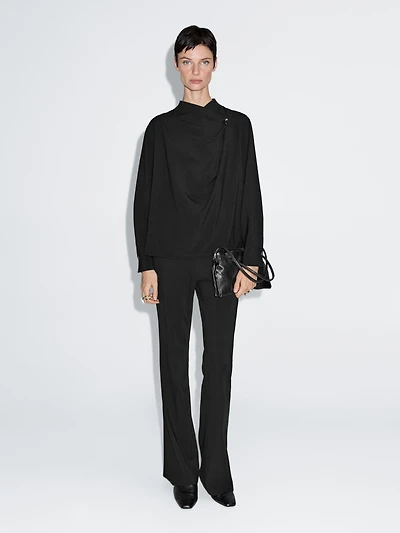 Blouse with crossover detail and button
