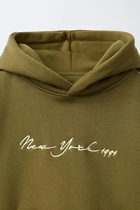 SWEAT À CAPUCHE AVEC INSCRIPTION BRODÉE