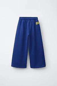 PANTALON À JAMBES LARGES ET BANDES SUR LES CÔTÉS