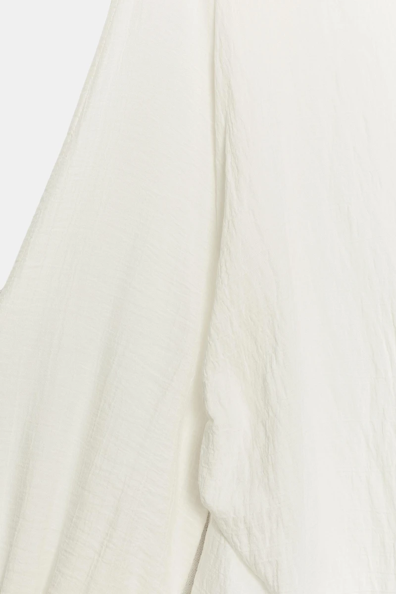 BLOUSE À OUVERTURES SUR LES MANCHES